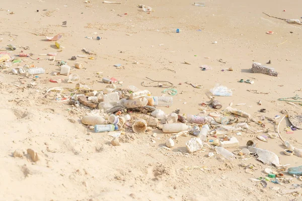 Trash on tropical Beach. Plastic pollution environmental problem. Plastic bottles and other garbage washed up on beach.