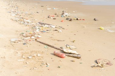 Tropik plajda çöp. Plastik kirliliği çevre sorunu. Plastik şişeler ve diğer çöpler sahile vurmuş..