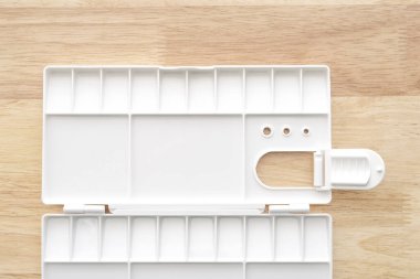 Beyaz suluboya palet. Boş suluboya tepsisi ahşap arka planda izole edilmiş. Beyaz plastik boya paleti.