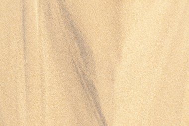 Kumsalda kum dokusu. Arka plan için kahverengi kumsal. Yakın plan..