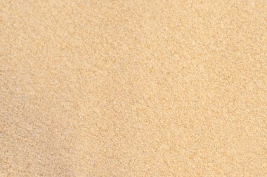 Tropikal plajda kum deseni. Arka plan için kahverengi kum. Yakın plan..