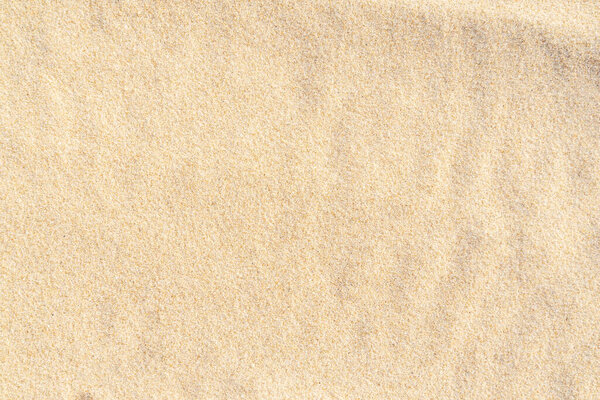 Sand texture on the beach. Brown beach sand for background. Close-up.