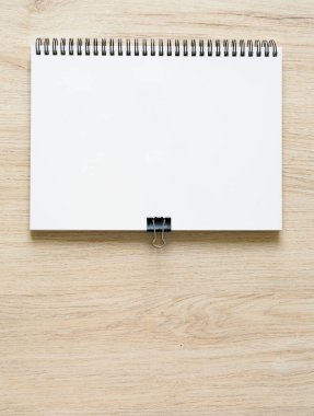 Tahta arka planda izole edilmiş, Kraft Kağıt kapaklı, boş spiral kaplı defter motifi. Yüksek çözünürlük.