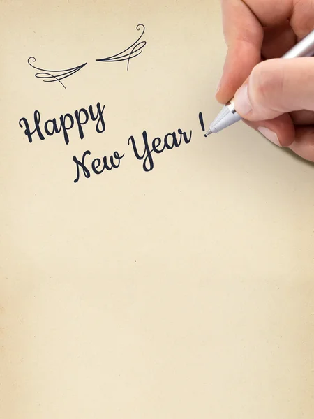 Hand schrijven "Happy New Year!" op leeftijd vel papier. — Stockfoto