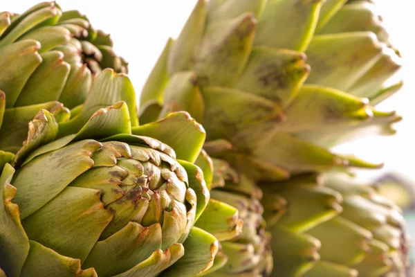 Pila de alcachofas frescas primer plano con luz natural —  Fotos de Stock
