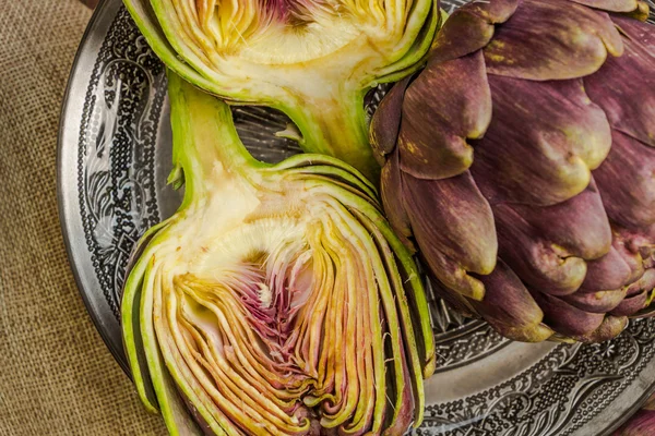 Fresco taglio viola carciofi in ciotola orientale primo piano sfondo — Foto Stock