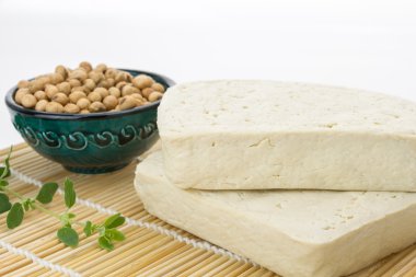 Tofu blokları ve soya fasulyesi, boşluk ile beyaz arka plan üzerine bir kase