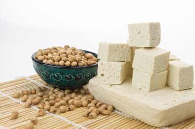 Tofu blok ve boşluk ile beyaz arka plan üzerinde kase soya fasulyesi ile kesme küpleri