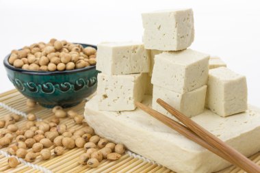 Tofu blok ve kesme küpleri ile soya fasulyesi, beyaz arka plan üzerinde.