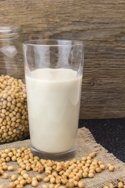 Soya fasulyesi ve soya süt, ahşap arka plan üzerinde.