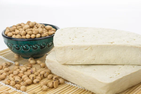 Bloques de tofu y tazón con soja, sobre fondo blanco con espacio para copiar — Foto de Stock