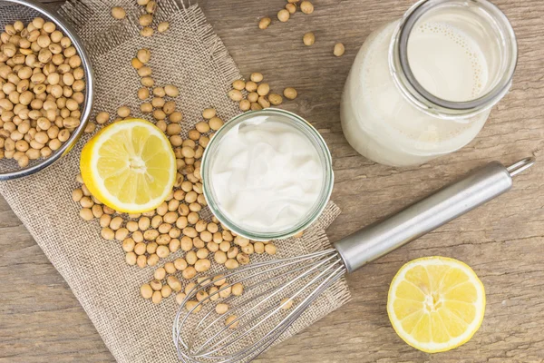 Sojová majonéza, citron, sojové boby a kovový bič, na dřevěné pozadí — Stock fotografie