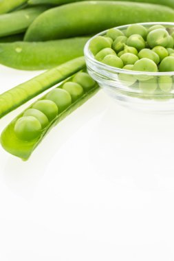 Taze yeşil bezelye ve boşluk ile beyaz arka plan üzerinde kase bezelye