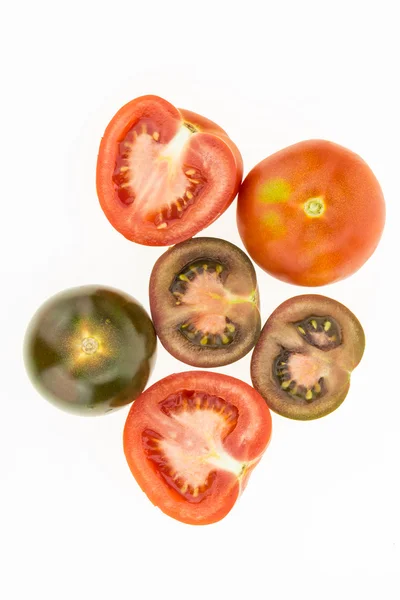 Tomates de kumato frescos e tomates vermelhos alguns cortados ao meio, isolados no fundo branco — Fotografia de Stock