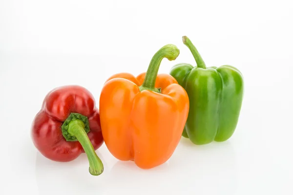Fresh orange, green and red bell peppers, isolated on white background. Royalty Free Stock Images