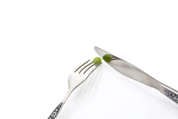 Guisante verde fresco en tenedor con cuchillo de primer plano, sobre fondo blanco con espacio de copia —  Fotos de Stock