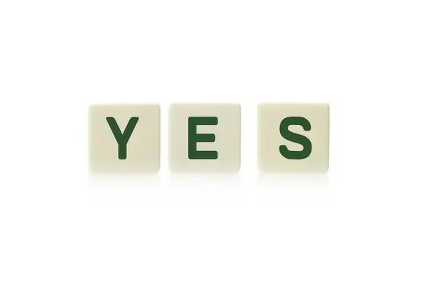 "Igen" szó fedélzetén játék négyszögletes műanyag cserép-darabokra, elszigetelt fehér background. — Stock Fotó