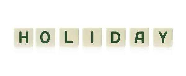 Woord "Holiday" aan boord van spel vierkant plastic tegel stukken, geïsoleerd op een witte achtergrond. — Stockfoto
