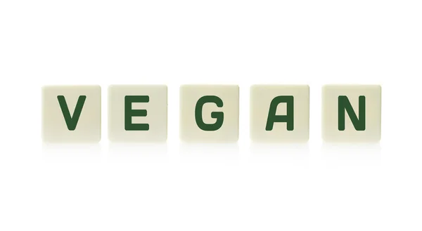 Word "Vegan" on board game square plastic tile pieces, isolated on a white background. — Stock Photo, Image