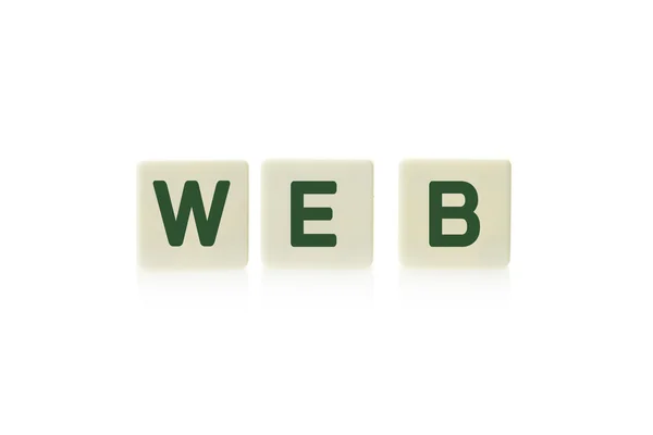 Palabra "Web" en el juego de mesa piezas de azulejos cuadrados de plástico, aislado sobre un fondo blanco . — Foto de Stock
