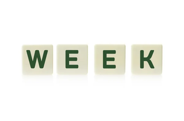 Word "Week" on board game square plastic tile pieces, isolated on a white background. — Stock Photo, Image