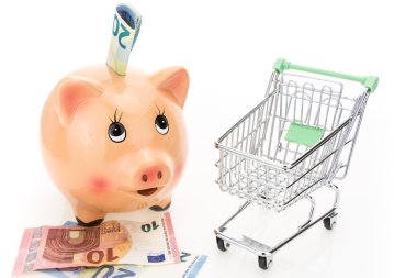 Para ve beyaz arka plan üzerinde boş alışveriş sepeti ile Piggy banka