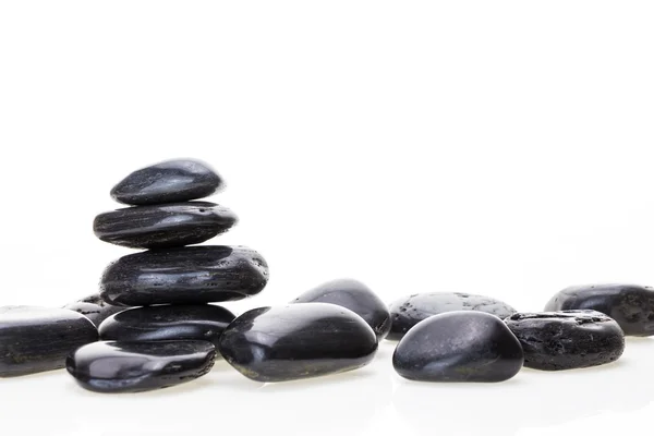 Stapel zwart basalt balancing stenen, op witte achtergrond. Stockfoto