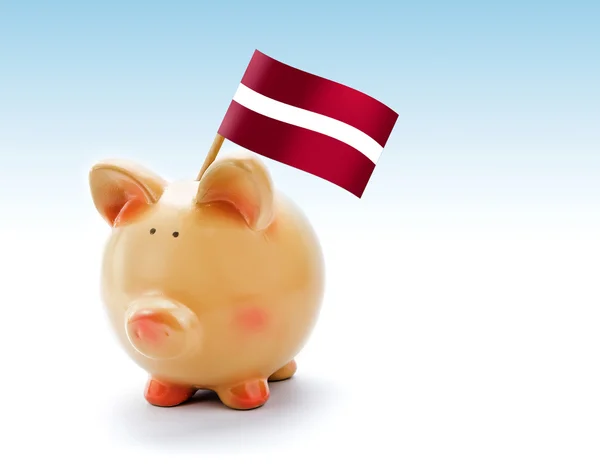 Банк свиней с государственным флагом Латвии — стоковое фото