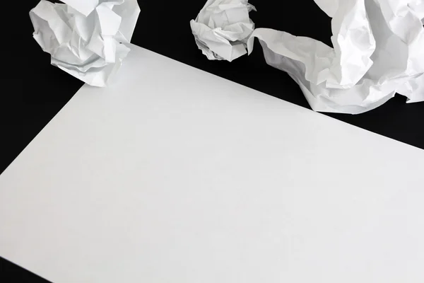 Hoja de papel en blanco y bolas de papper arrugadas aisladas — Foto de Stock