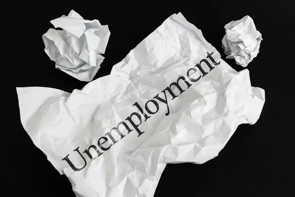 Τσαλακωμένο χαρτί φύλλο με λέξη ανεργίας που απομονώνονται σε μαύρο — Φωτογραφία Αρχείου