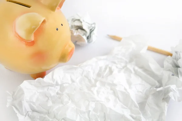 Piggy bank met sommige verfrommeld papier en potlood. — Stockfoto