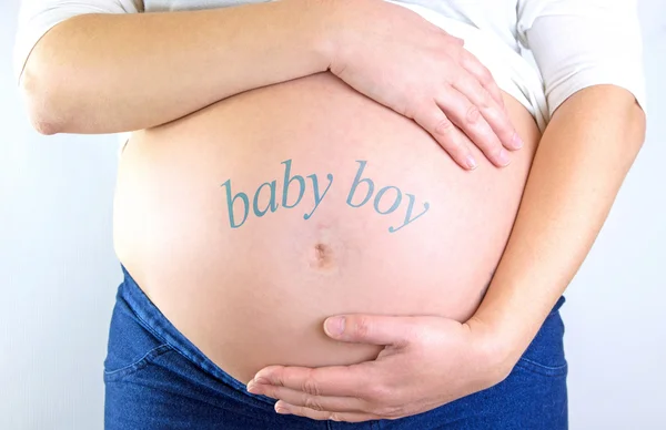 Ventre de femme enceinte avec texte "bébé garçon" — Photo