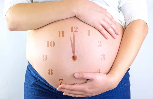 Pregnant woman belly with clock illustration — Stock Photo, Image