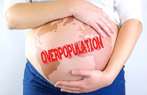 Ventre de femme enceinte avec Timbre sur la surpopulation et carte — Photo