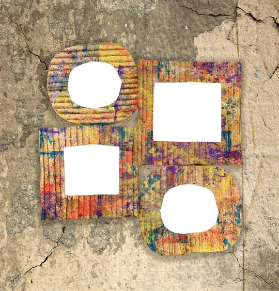 Group of blank colorful painted cardboard frames on grunge wall — Stock Photo, Image