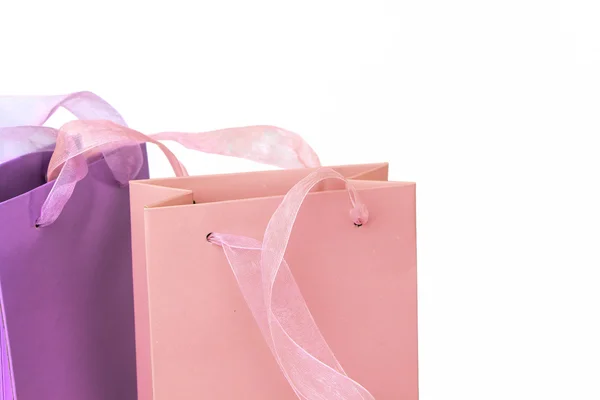 Pastel rosa e lilás coloridos sacos de compras tops close-up isolado — Fotografia de Stock
