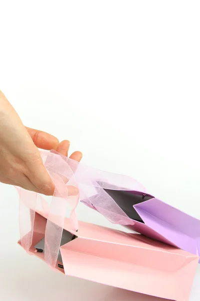 Mano sosteniendo coloridas bolsas de compras aisladas en blanco — Foto de Stock