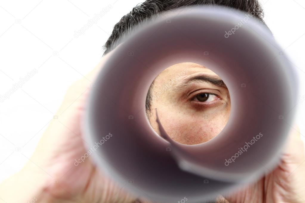 Male face looking in the rolled paper like a spyglass