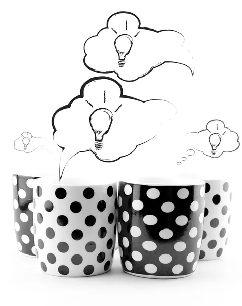 Coffee mugs with speech bubbles and light bulbs isolated on white — Stock Photo, Image