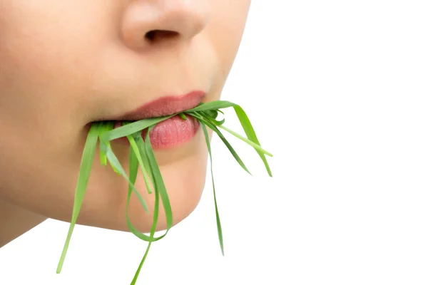Kobieta z wheatgrass w jej usta, na białym tle. — Zdjęcie stockowe