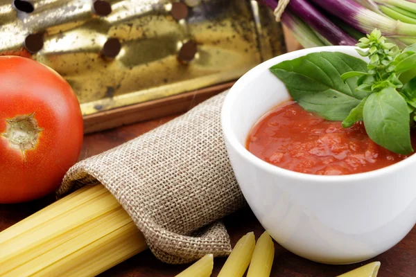 Salsa de tomate con hojas de albahaca fresca y tomates — Foto de Stock