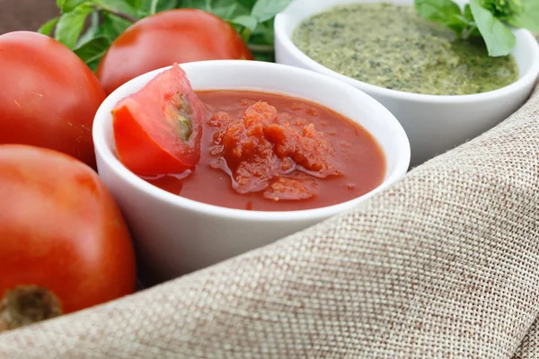 Salsa de tomate y pesto con hojas de albahaca fresca y tomates — Foto de Stock