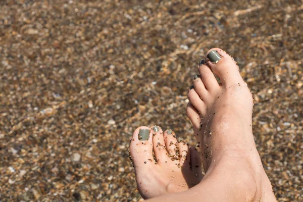 Pés femininos molhados pela água na areia — Fotografia de Stock