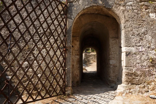 Antico cancello in pietra con porta in metallo — Foto Stock