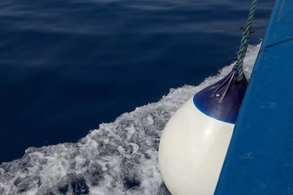 Paisaje marino con rastro de agua desde el barco con foco en guardabarros de bolas blancas — Foto de Stock