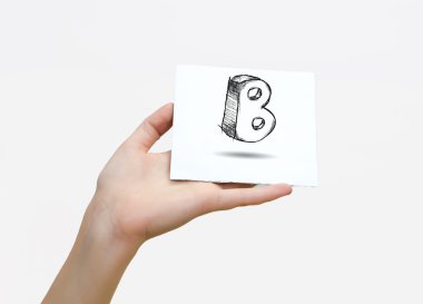 Hand holding a piece of paper with sketchy capital letter B, isolated on white.