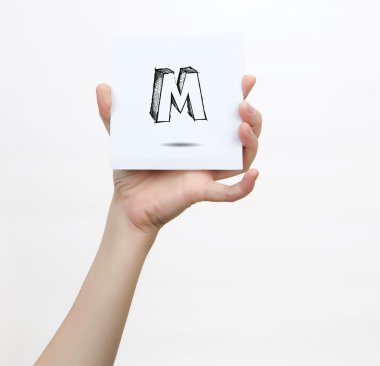 Hand holding a piece of paper with sketchy capital letter M, isolated on white.