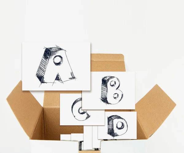 Sketchy capital letters on cards in box, isolated on white. — Stock Photo, Image