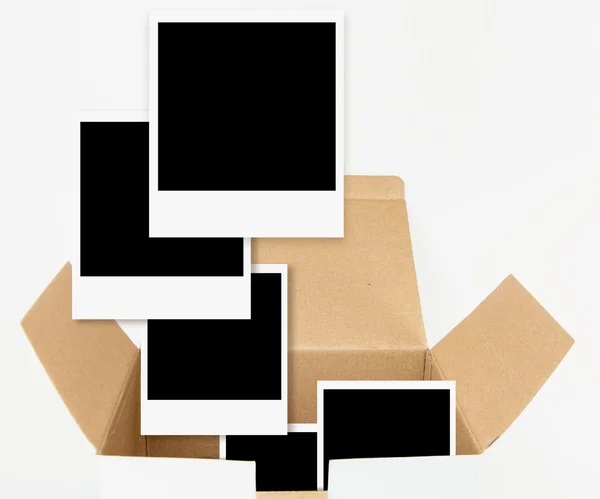 Caixa de papelão aberta com modelos de fotografia, isolada em branco . — Fotografia de Stock
