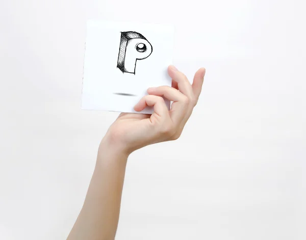 Hand holding a piece of paper with sketchy capital letter  P, isolated on white. — Stockfoto